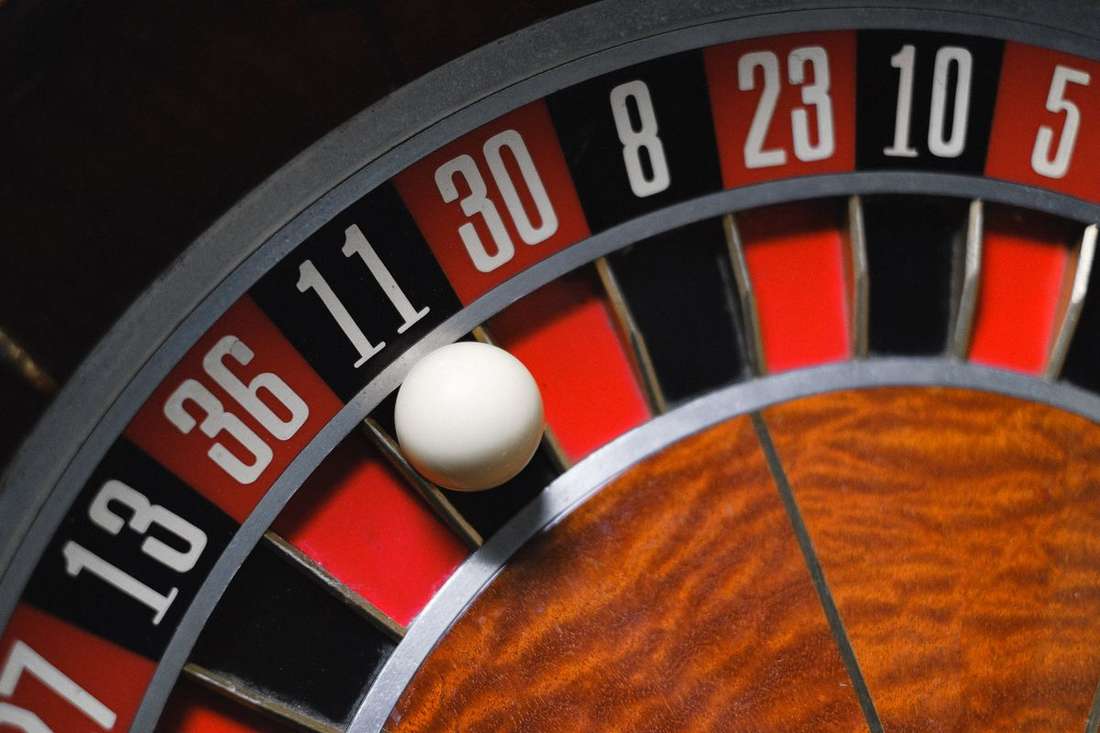 Meja roulette dengan roda berputar di studio dealer langsung