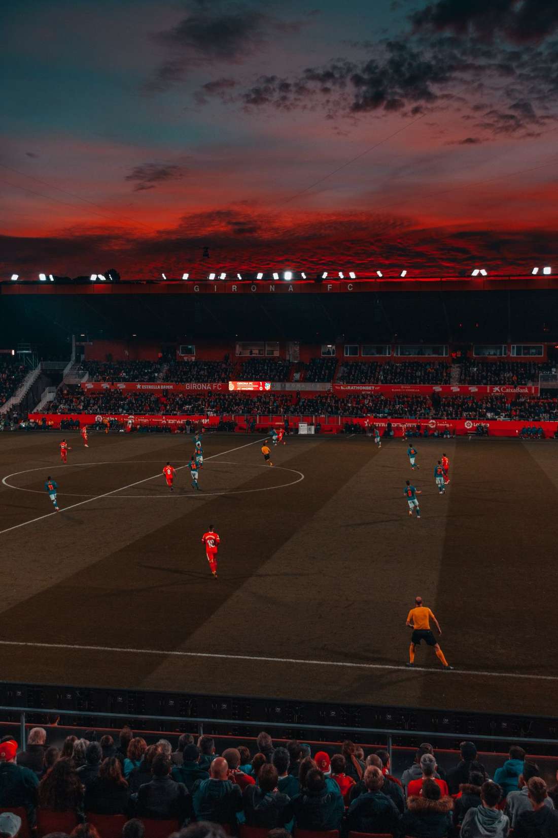 Stadion sepak bola dengan lampu sorot menyala malam